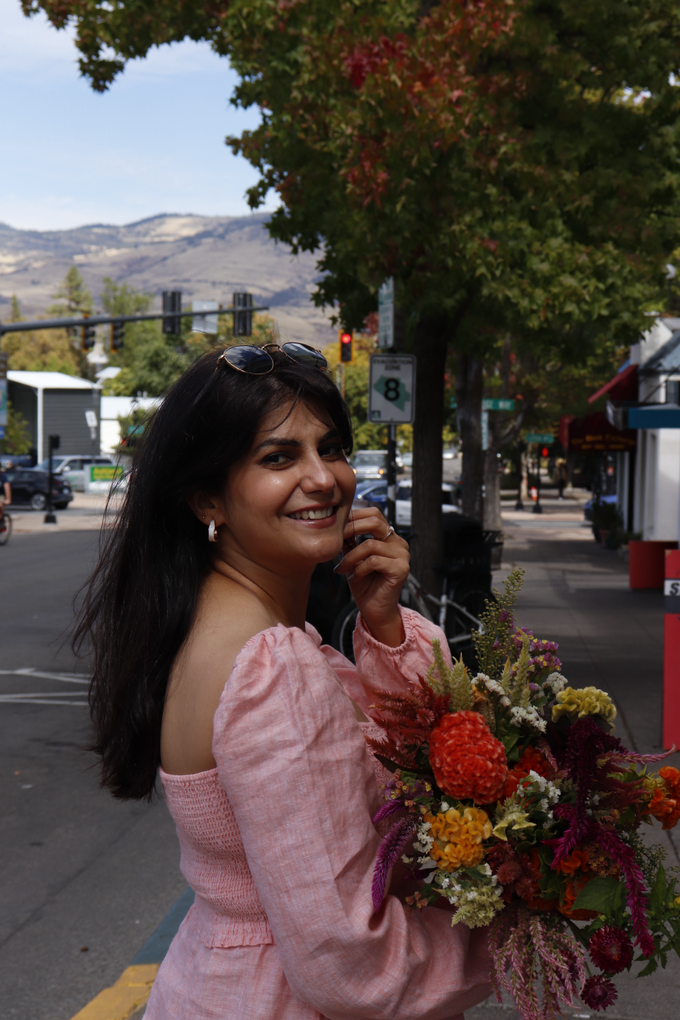 Moon Sheoran holding a colorful bouquet in downtown Ashland, Oregon
