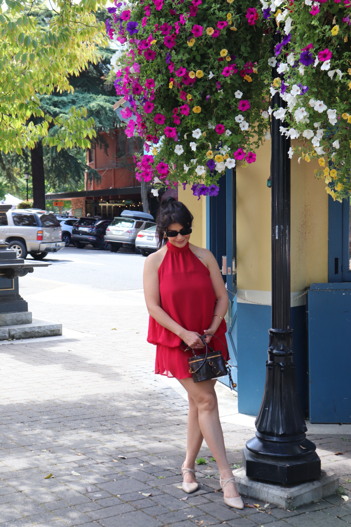Moon Sheoran in a red dress beside colorful flowers