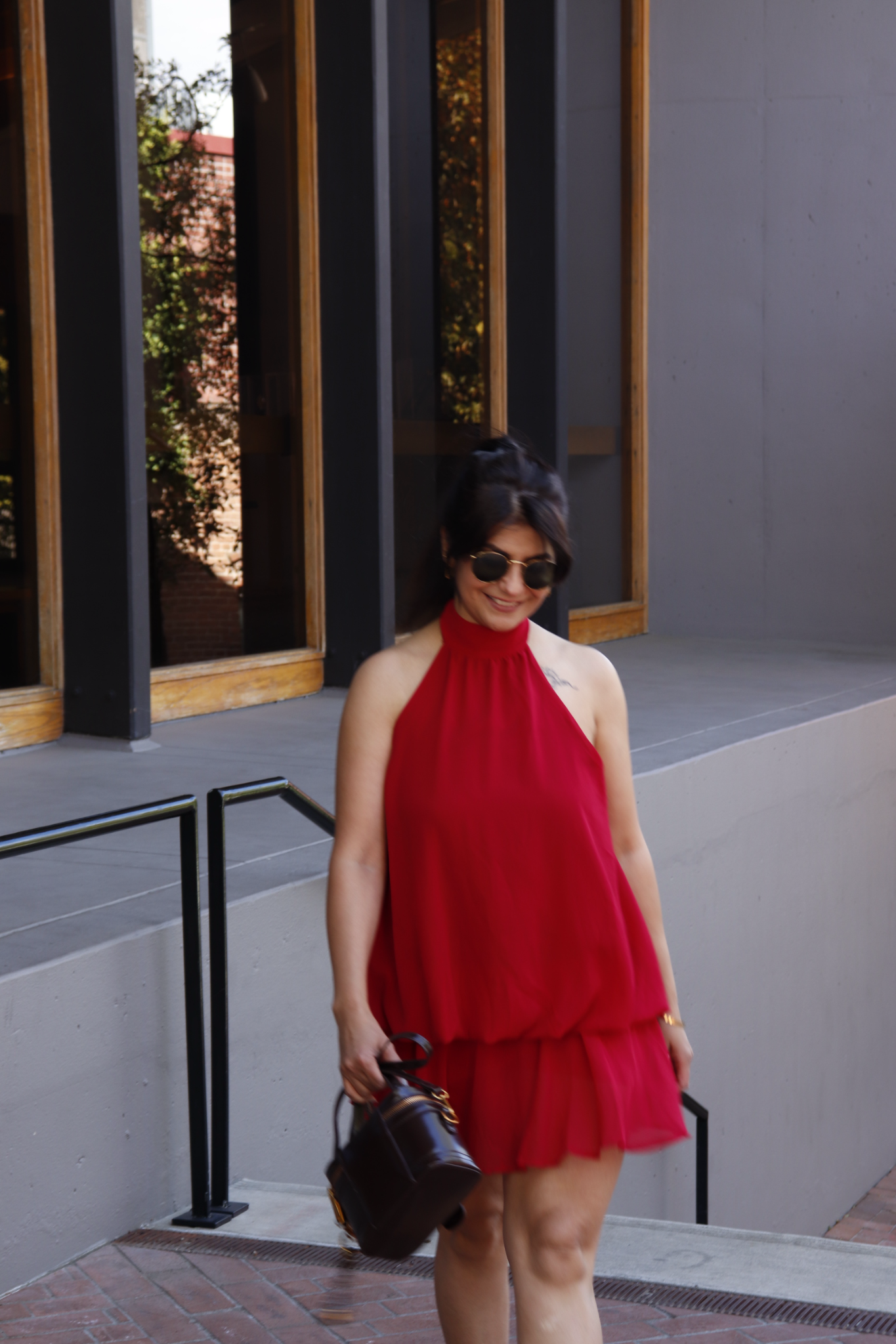 Moon Sheoran smiling in a red dress outdoors